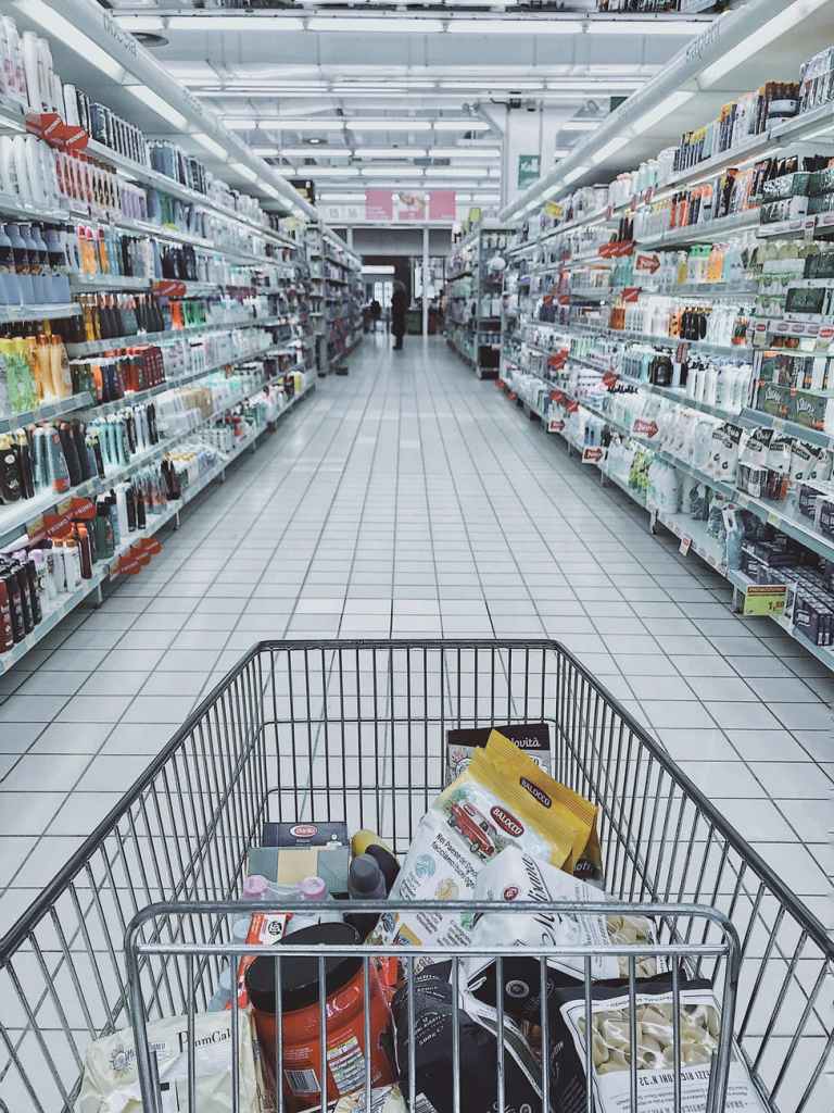 grocery cart with items in store aisle