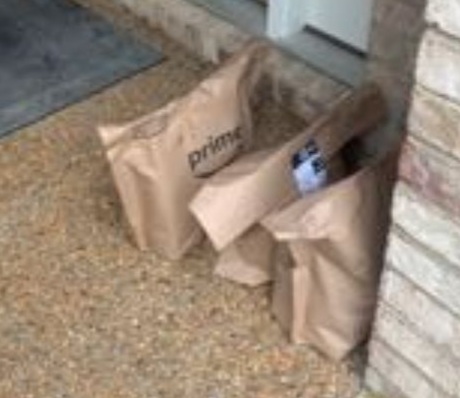 Amazon Fresh bags next to door.