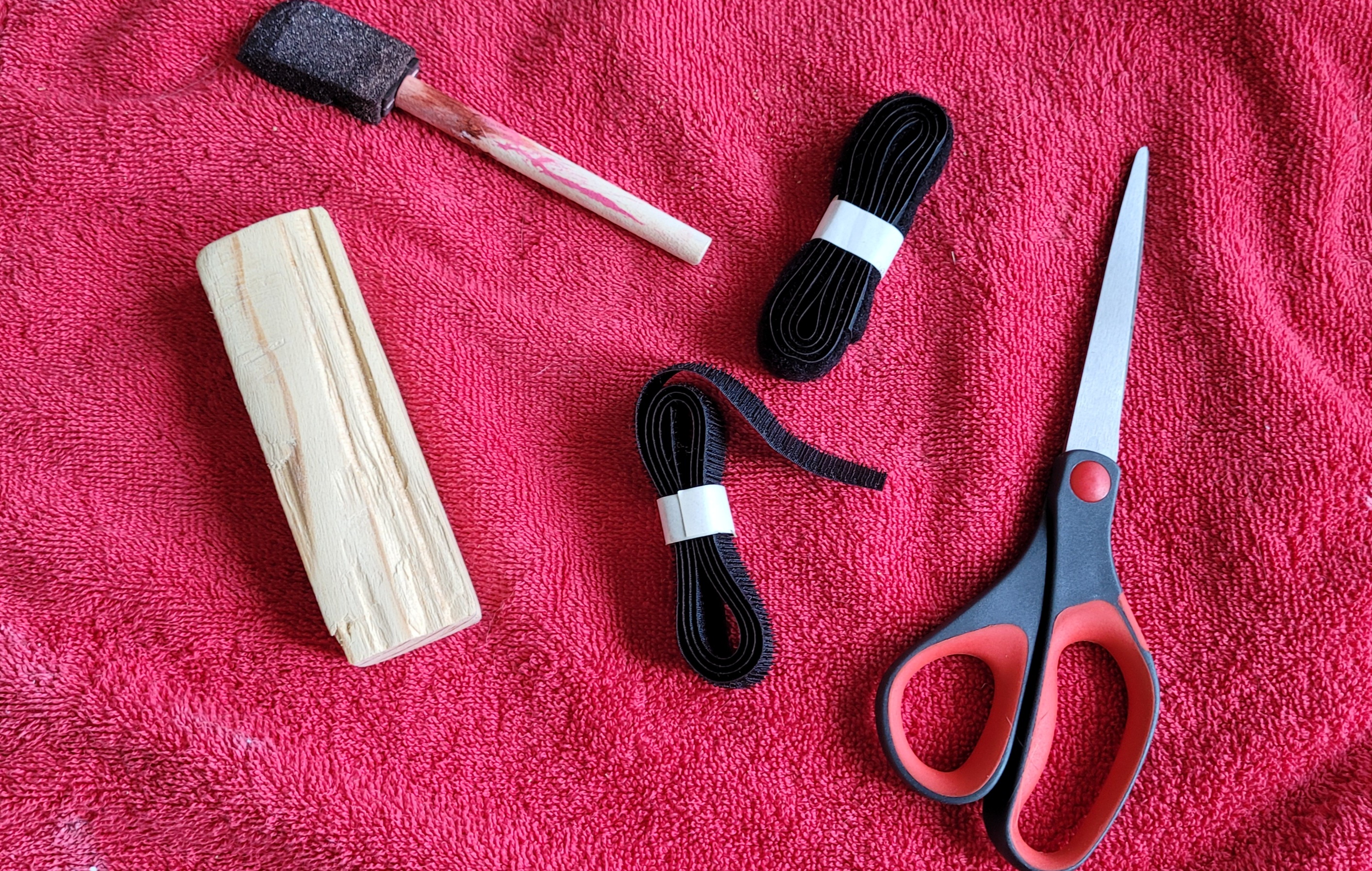 Cut wood, paint brush, velcro tape, and scissors.