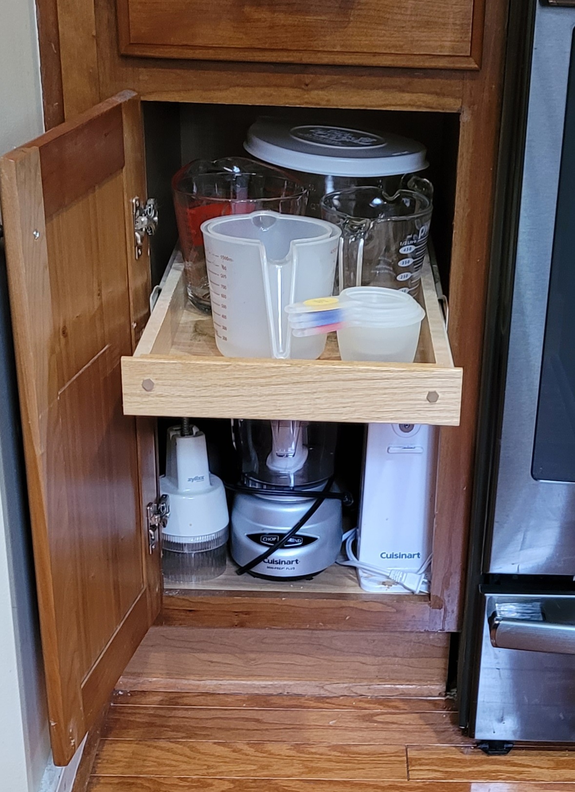 Cabinet pull out shelf with measuring cups.